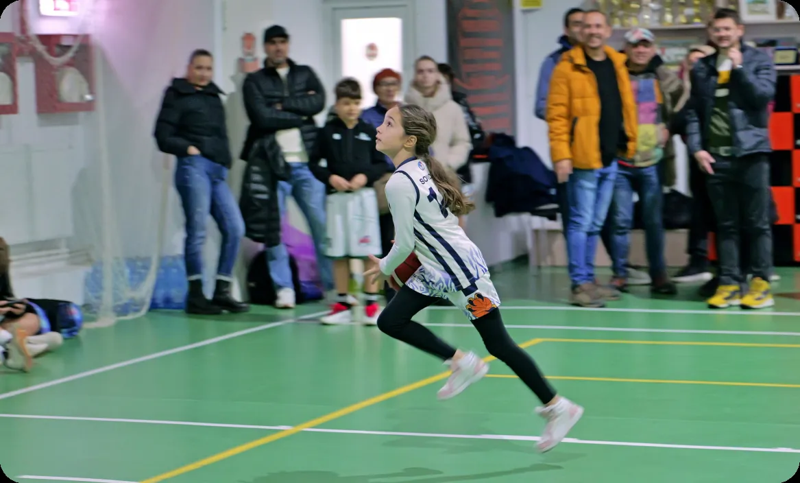 Fiatal kosárlabdázó szülőkkel a háttérben